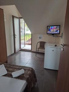 a room with a bed and a television on a wall at Casa Ancuta in Eforie Sud