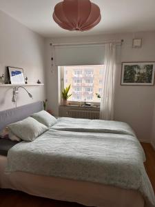 a bedroom with a large bed and a window at Eurovision apartment in central Malmö in Malmö