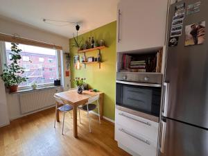 a kitchen with a table and a refrigerator at Eurovision apartment in central Malmö in Malmö