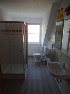 La salle de bains est pourvue de 2 lavabos, de toilettes et d'une fenêtre. dans l'établissement Ferienwohnung auf dem Lande, à Loxstedt