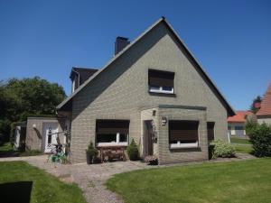 une maison en briques avec deux fenêtres et une pelouse dans l'établissement Ferienwohnung auf dem Lande, à Loxstedt