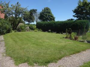 een grote tuin met groen gras en struiken bij Ferienwohnung auf dem Lande in Loxstedt