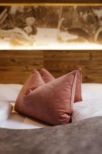 a brown pillow sitting on top of a bed at Dolomite Apartments - by Familiaris in San Candido