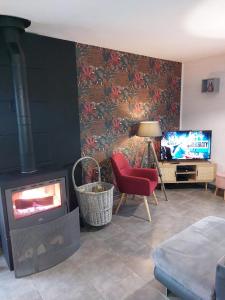 un salon avec une cheminée et une télévision dans l'établissement Entre Lacs Et Montagnes , Maison individuelle,lits préparés, parking et ménage inclus, à Barésia-sur-lʼAin