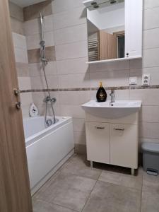 La salle de bains est pourvue d'un lavabo, d'une baignoire et de toilettes. dans l'établissement Fiald Apartament nou, à Bacău