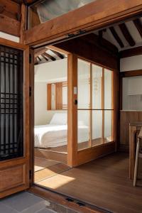 a room with a bed and a glass door at Luxury hanok with private bathtub -SN15 in Seoul