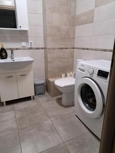 La salle de bains est pourvue d'un lave-linge et de toilettes. dans l'établissement Fiald Apartament nou, à Bacău