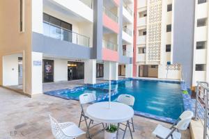 a pool in the courtyard of a building with a table and chairs at Mombasa Nyali Beachfront Apt in Mombasa