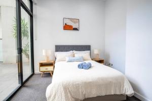 a bedroom with a bed with two blue pillows on it at Cozy Retreat in Sydney CBD in Sydney