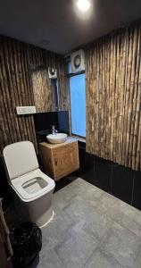 a bathroom with a toilet and a sink at Aloha Riverside in Kasol