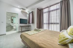 a bedroom with a large bed and a bathroom at Jules Suites in St. Julianʼs