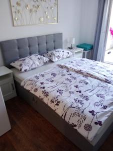 a bedroom with a bed with a floral bedspread at Apartmani Marina in Rab