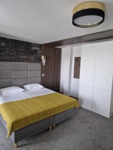 - une chambre avec un grand lit et une couverture jaune dans l'établissement Hotel City Break, à Galaţi