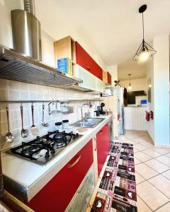 een keuken met rode kasten en een fornuis met oven bij La Corte del Principe in Bracciano