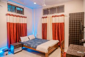 ein kleines Schlafzimmer mit einem Bett und Vorhängen in der Unterkunft bornil guest house in Guwahati