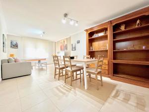 a living room with a table and chairs and a couch at Apartamento en la playa! in Sanxenxo