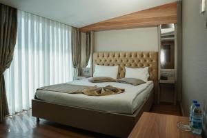 a bedroom with a large bed with a large window at Enerji Otel in Ankara