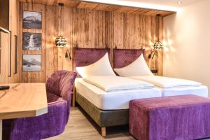 een hotelkamer met een bed en een stoel bij Hotel Lärchenhof in Lermoos