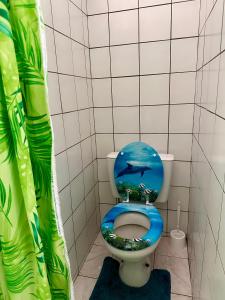 a bathroom with a blue toilet with a fish on the seat at « Le Green House » by Meri lodge Huahine in Fare