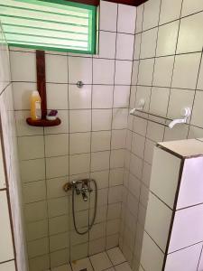 uma casa de banho com um chuveiro e uma porta de vidro em « Le Green House » by Meri lodge Huahine em Fare
