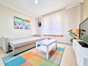 a living room with a couch and a table at Apartamento en la playa! in Sanxenxo