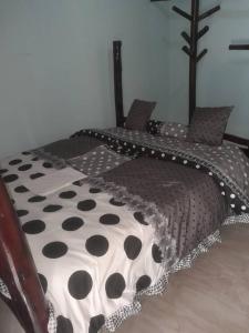 a bed with a black and white polka dot bedspread at KWERI GUEST HOUSE in Mbarara