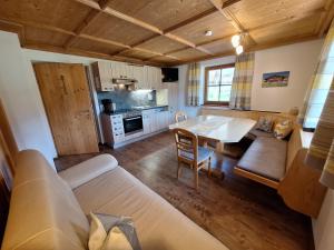 a living room with a table and a kitchen at BIO- Bauernhof Obermaurach in Walchsee