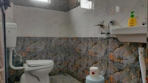 a bathroom with a toilet and a sink at Milan Palace Deoghar in Deoghar