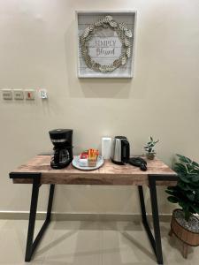 a wooden table with a coffee maker on it at شقق نسج المسكن دخول ذاتي شمال الرياض in Riyadh