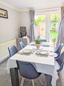 a dining room with a white table and chairs at A Home from Home - Leamington Spa in Leamington Spa