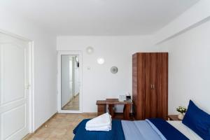 a bedroom with a blue bed and a mirror at Casa Irina 2Mai in 2 Mai