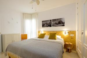 sypialnia z dużym łóżkiem z 2 żółtymi poduszkami w obiekcie LOFT2STAY.COM w Maladze