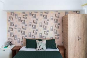 a bedroom with a green bed and a wall with at Casa Irina 2Mai in 2 Mai