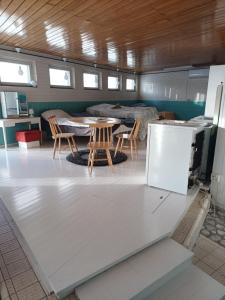 een kamer met een tafel en stoelen en een koelkast bij Majoitus Yli-Torkko in Seinäjoki