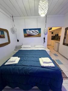 a bedroom with a blue bed with towels on it at Naval Hotel Aegina in Egina