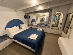 a bedroom with a bed with two towels on it at Naval Hotel Aegina in Egina
