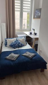 a bedroom with a blue bed with towels on it at Szeroka Royal Rooms in Gdańsk