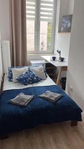 Un dormitorio con una cama azul con toallas. en Szeroka Royal Rooms, en Gdansk