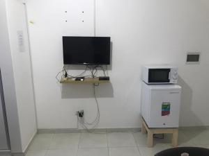 a room with a television and a small refrigerator at 2SB Hospedagem in Praia