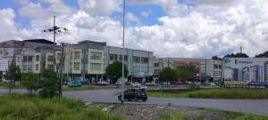 a car driving down a road in front of a building at Moyan Square By Natol Homestay in Kuching