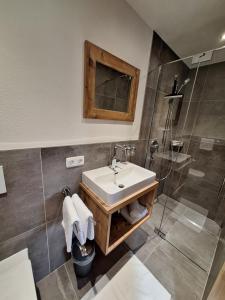 uma casa de banho com um lavatório e um chuveiro em BIO- Bauernhof Obermaurach em Walchsee