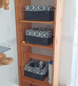 a book shelf with baskets in a bathroom at Casa de campo con piscina in Chiclana de la Frontera