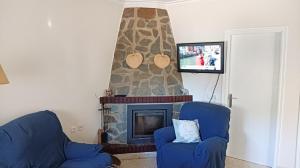 sala de estar con chimenea y TV en Casa de campo con piscina en Chiclana de la Frontera