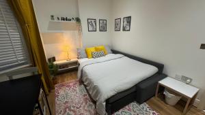 a small bedroom with a bed with a yellow pillow at Sunny in London