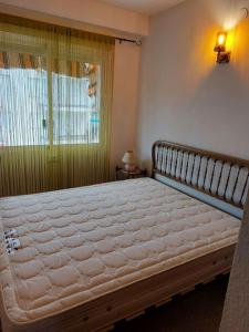 ein großes Bett in einem Schlafzimmer mit Fenster in der Unterkunft Apartamento Coral con vistas al mar in Playa de Gandia