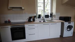 uma cozinha com um lavatório e uma máquina de lavar roupa em Appartement BLUEMA 2 chambres RdC em Vitré