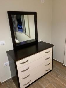 a dresser with a mirror on top of it at Durres, Golem, Grand Apartament in Golem