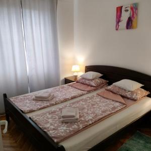 a bedroom with two twin beds with pink sheets at Apartman "Plitvice and You" in Plitvička Jezera