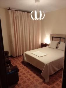 una camera con letto e lampadario a braccio di Habitacion matrimonial centro ciudad a Oviedo