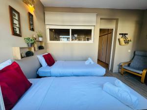 een slaapkamer met twee bedden en een stoel en een raam bij Casa Azul in Torreira